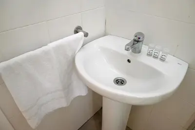 a white sink in a bathroom with a towel at Homenfun Barcelona Park Güell in Barcelona