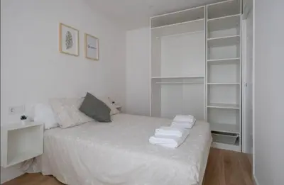 a bedroom with a white bed with towels on it at Apartment close to the beach in Sant Adria de Besos