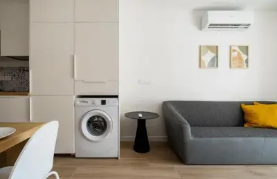 a living room with a couch and a washing machine at Apartment close to the beach in Sant Adria de Besos