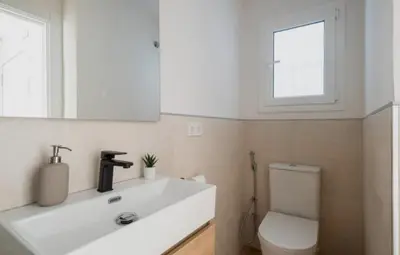 a bathroom with a sink and a toilet and a mirror at Apartment close to the beach in Sant Adria de Besos