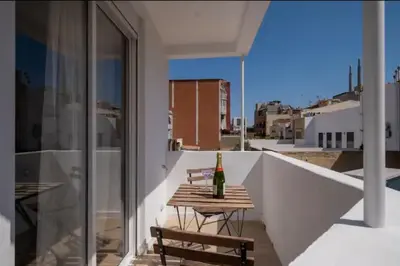 a bottle of wine on a wooden table on a balcony at Apartment close to the beach in Sant Adria de Besos