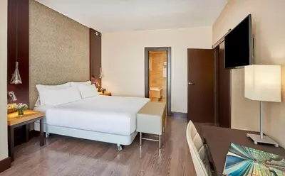a hotel room with a bed and a television at NH Barcelona Eixample in Barcelona