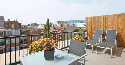 a balcony with three chairs and a table on a building at NH Barcelona Les Corts in Barcelona