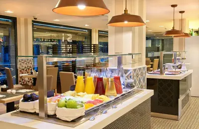 a display case in a restaurant with fruits and juice at NH Barcelona Les Corts in Barcelona