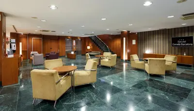 a lobby with chairs and tables and a staircase at Sercotel Cornellà Barcelona in Cornellà de Llobregat
