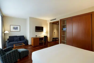a hotel room with a bed and a living room at Sercotel Cornellà Barcelona in Cornellà de Llobregat