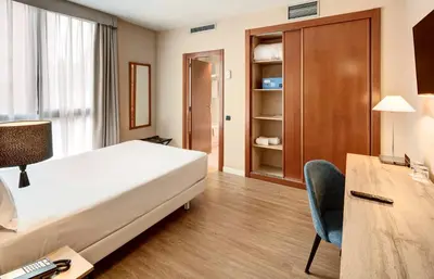 a hotel room with a bed and a desk and a chair at Sercotel Cornellà Barcelona in Cornellà de Llobregat