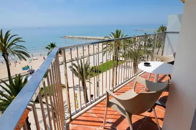 a balcony with chairs and a view of the beach at Hotel Subur in Sitges