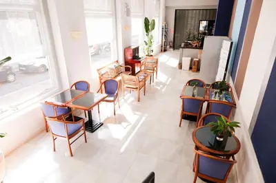 a restaurant with tables and chairs and a window at Hotel Subur in Sitges