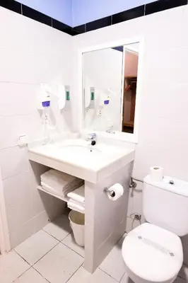 a white bathroom with a sink and a toilet at Hotel Subur in Sitges