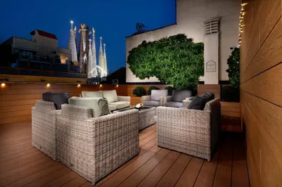 a rooftop patio with wicker chairs and a tree at Apartaments-Hotel Hispanos 7 Suiza in Barcelona