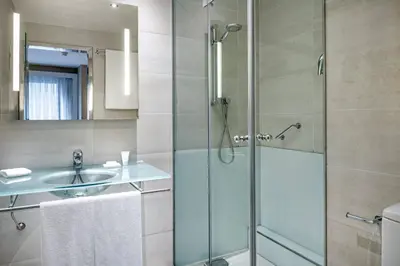 a bathroom with a glass shower and a sink at AC Hotel Irla by Marriott in Barcelona
