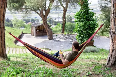 a man laying in a hammock in a garden at Augusta Barcelona Vallès in Granollers