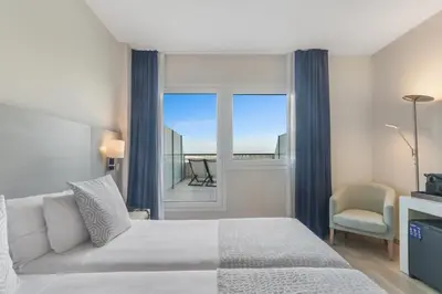 a bedroom with a bed and a window and a chair at Augusta Barcelona Vallès in Granollers
