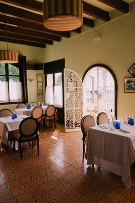a dining room with tables and chairs and windows at Hotel Subur Maritim in Sitges