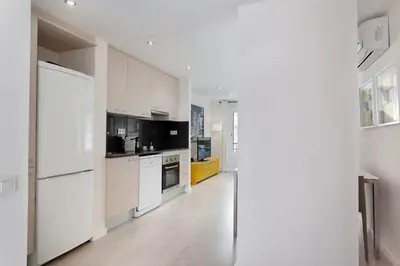 a white kitchen with white cabinets and appliances at BarcelonaForRent Urban Town Suites in Barcelona