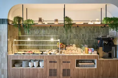 a bakery with a counter with food on it at Catalonia La Maquinista in Barcelona