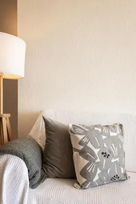 a white couch with two pillows and a lamp at LETS HOLIDAYS Beach front apartment in Gavà Mar, Pine Beach in Gavà