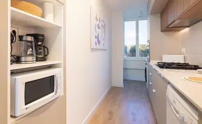 a kitchen with a microwave and a counter top at LETS HOLIDAYS Beach front apartment in Gavà Mar, Pine Beach in Gavà