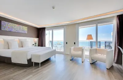 a bedroom with a large bed with a view of the ocean at Calipolis in Sitges