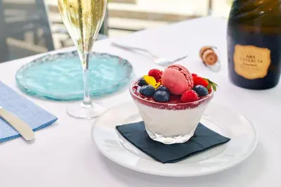 a bowl of fruit on a plate with a glass of wine at Calipolis in Sitges