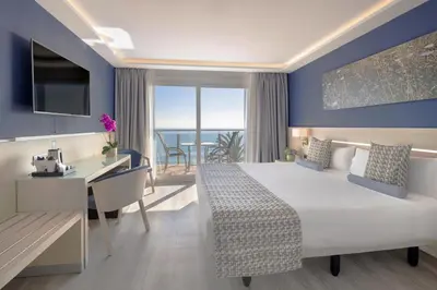 a hotel room with a bed and a desk with a view at Calipolis in Sitges