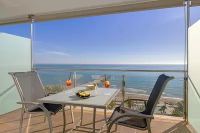 a table and chairs on a balcony with a view of the ocean at Calipolis in Sitges