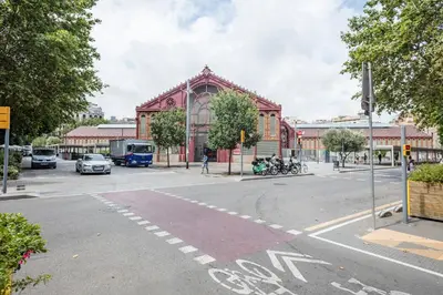 an intersection of a street with a large red building at Alcam Books in Barcelona