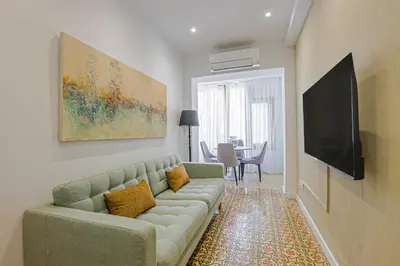 a living room with a couch and a flat screen tv at Alcam Books in Barcelona