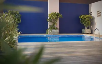 a swimming pool with blue walls and potted plants at Onix Rambla in Barcelona