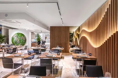 a restaurant with wooden tables and chairs at Salles Ciutat del Prat Barcelona Airport in El Prat de Llobregat