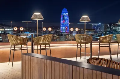 a rooftop bar with chairs and a view of the city at Sallés Hotel Pere IV in Barcelona