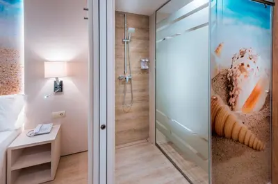 a bathroom with a shower with a glass door at Sumus Hotel Stella and Spa 4S Adults Recommended in Pineda de Mar