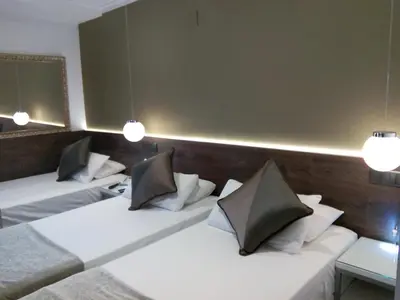 two beds in a hotel room with two lamps at Moderno in Barcelona