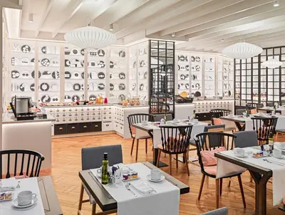 a restaurant with tables and chairs and a counter with dishes at H10 Universitat in Barcelona