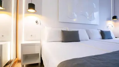a bedroom with a large bed with white pillows at Evenia Rocafort in Barcelona