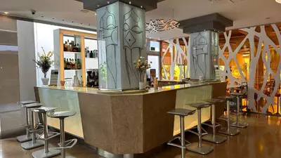 a bar in a restaurant with stools at Evenia Rossello in Barcelona