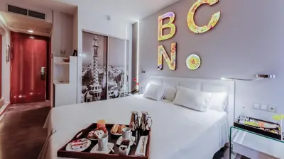 a bedroom with a white bed with a sign on the wall at Evenia Rossello in Barcelona