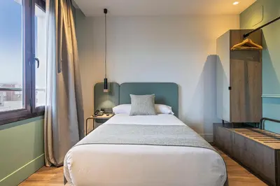 a bedroom with a large bed and a window at Hotel Via Augusta in Barcelona