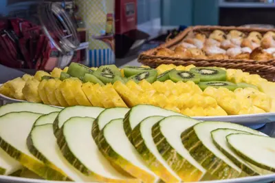 a plate of food with pickles and fruit on a table at Hotel Via Augusta in Barcelona