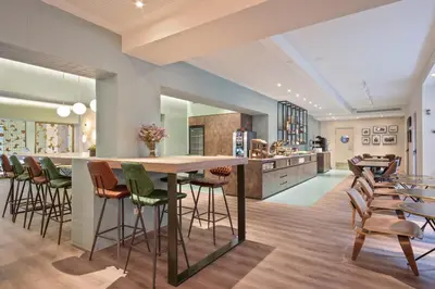 a kitchen with a bar with chairs and tables at Hotel Via Augusta in Barcelona