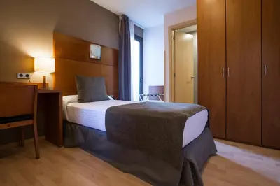 a hotel room with a bed and a dresser at Hotel Via Augusta in Barcelona