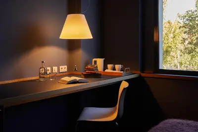 a desk with a chair and a lamp and a window at El Sant Cugat, 4 estrellas superior in Sant Cugat del Vallès
