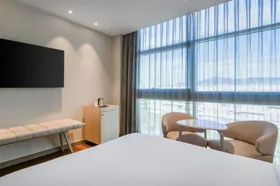 a hotel room with a bed and a large window at AC Hotel Som by Marriott in Hospitalet de Llobregat