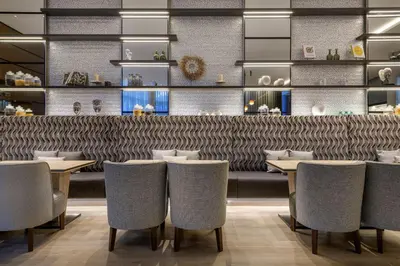 a restaurant with tables and chairs and a bar at AC Hotel Som by Marriott in Hospitalet de Llobregat