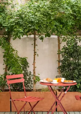 a table and a chair and a table with food on it at BYPILLOW Mothern in Barcelona
