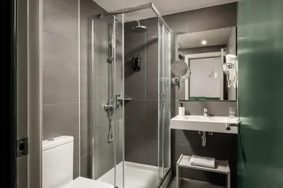 a bathroom with a shower and a toilet and a sink at BYPILLOW Mothern in Barcelona