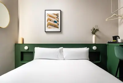 a bedroom with a white bed with a green headboard at BYPILLOW Mothern in Barcelona