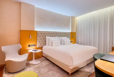 a bedroom with a large white bed and a desk at Sansi Pedralbes in Barcelona