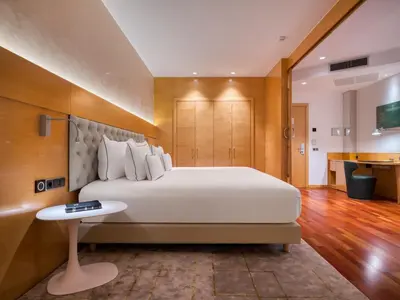 a bedroom with a large white bed and a table at Sansi Pedralbes in Barcelona